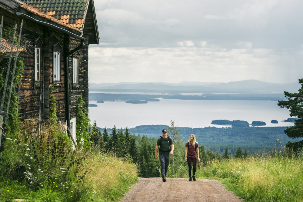 Ett par går på en väg med sjö i bakgrunden