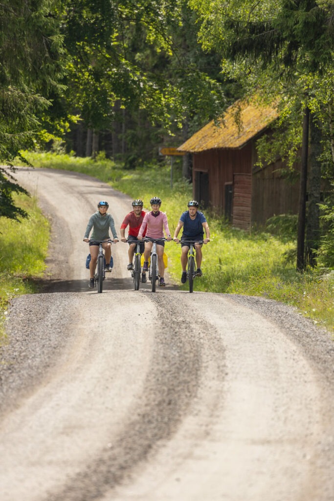 En grupp människor som cyklar på en landsväg