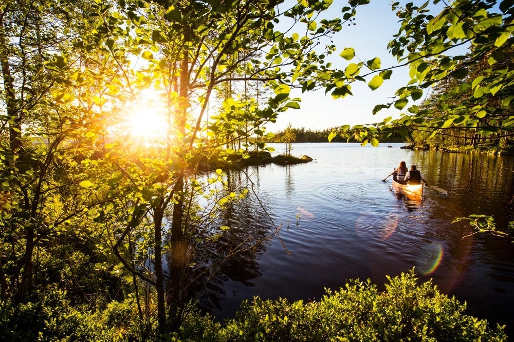 Kanot i vattnet vid solnedgång