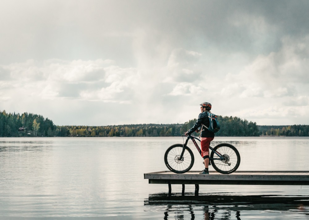 Mountainbike-cyklist på bryggan vid en sjö