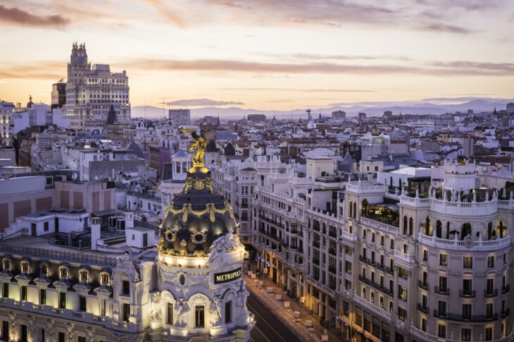 Madrids skyline vid solnedgång med Metropolis-byggnaden i förgrunden.